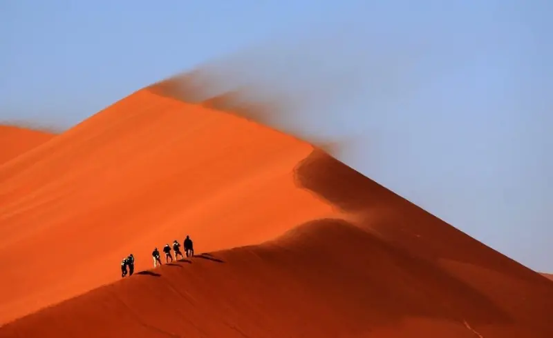 Grupo de viajeros subiendo la duna Sossusvlei