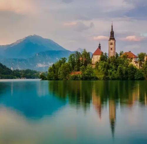 Lago Bled con iglesia en la isla y montañas al fondo en Eslovenia