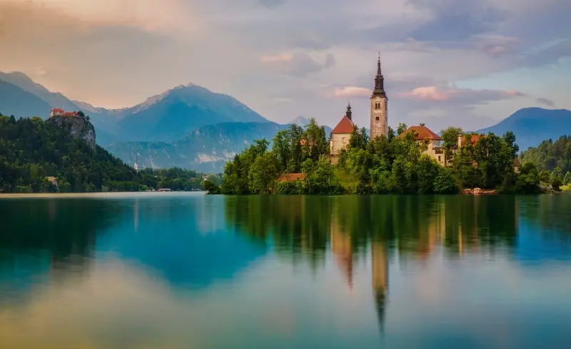 Lago Bled con iglesia en la isla y montañas al fondo en Eslovenia