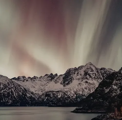 Auroras boreales sobre montañas nevadas en Finlandia