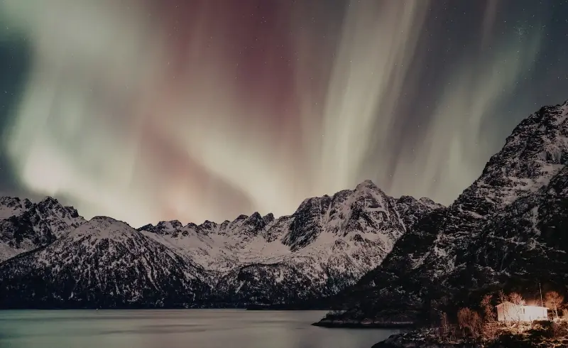 Auroras boreales sobre montañas nevadas en Finlandia